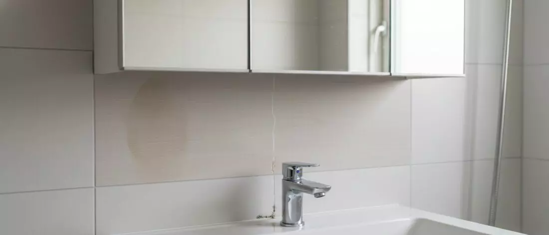 Home lekdetectie Hoe vind je een druppellek in een badkamerleiding achter een spiegelkast?