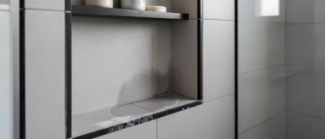 Hoe spoor je een lekkage op in een nis van een inloopdouche met donkere voegen? Wat is een lekkage in de nis van een inloopdouche met donkere voegen