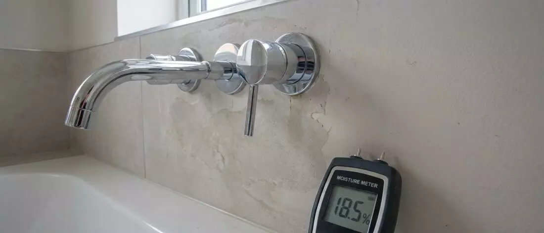 Wat is vocht in een badkamermuur door een lekkende mengkraan