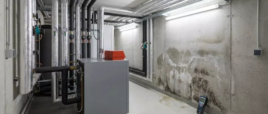 Wat is vocht in een muur vanuit een aangrenzende technische ruimte
